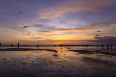 İnsanlar gün batımında Seminyak sahilinde, Bali Adası, Endonezya