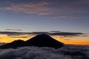 Agung Dağı üzerinde gün doğumu Batur Dağı, Bali, Endonezya 'dan görülüyor.