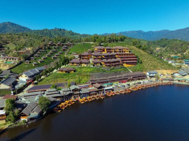 Aerial view of the Chinese village of Ban Rak Thai with tea plantations and a lake, Thailand clipart