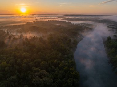 Sabah sisi ve yükselen güneşin doğal Drava Nehri üzerindeki hava manzarası ve orman taşkın ovası.