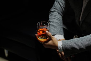 Closeup businessmen holding a glass of whiskey clipart