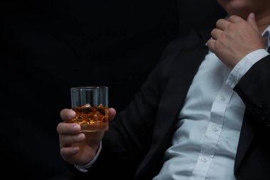 Yakından bir bardak viski tutan iş adamları.
