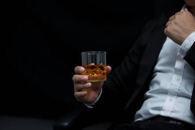 Yakından bir bardak viski tutan iş adamları.