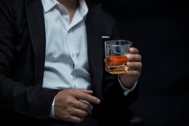Yakından bir bardak viski tutan iş adamları.