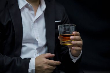 Yakından bir bardak viski tutan iş adamları.