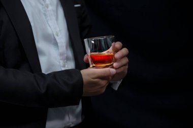 Yakından bir bardak viski tutan iş adamları.