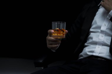 Yakından bir bardak viski tutan iş adamları.