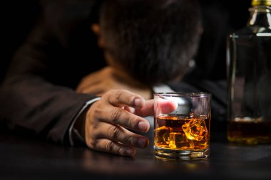 Yakından bir bardak viski tutan iş adamları.