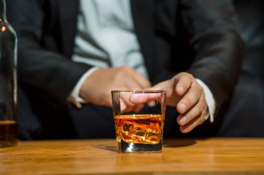 Yakından bir bardak viski tutan iş adamları.