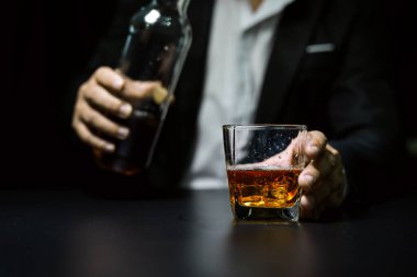 Yakından bir bardak viski tutan iş adamları.