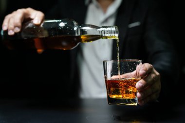 Yakından bir bardak viski tutan iş adamları.