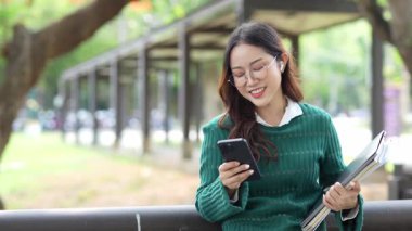  Ofis dışındayken Asyalı iş kadınının cep telefonu kullanması, mesajlaşması ve aldatması..