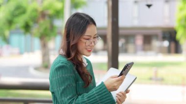  Ofis dışındayken Asyalı iş kadınının cep telefonu kullanması, mesajlaşması ve aldatması..