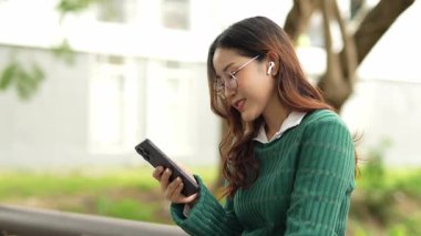  Ofis dışındayken Asyalı iş kadınının cep telefonu kullanması, mesajlaşması ve aldatması..