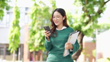  Ofis dışındayken Asyalı iş kadınının cep telefonu kullanması, mesajlaşması ve aldatması..