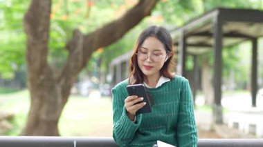  Ofis dışındayken Asyalı iş kadınının cep telefonu kullanması, mesajlaşması ve aldatması..