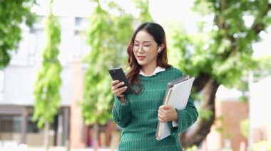 Ofis dışındayken Asyalı iş kadınının cep telefonu kullanması, mesajlaşması ve aldatması..