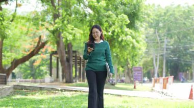  Ofis dışındayken Asyalı iş kadınının cep telefonu kullanması, mesajlaşması ve aldatması..