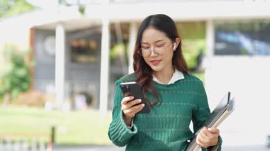  Ofis dışındayken Asyalı iş kadınının cep telefonu kullanması, mesajlaşması ve aldatması..