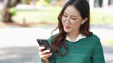  Ofis dışındayken Asyalı iş kadınının cep telefonu kullanması, mesajlaşması ve aldatması..