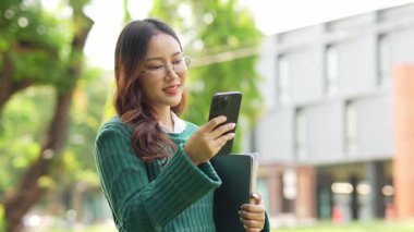  Ofis dışındayken Asyalı iş kadınının cep telefonu kullanması, mesajlaşması ve aldatması..