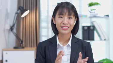 Masada çalışan Asyalı iş kadını dizüstü bilgisayar ve not defteri kullanarak müşteri ya da ofis binasıyla konuşuyor, yavaş çekim görüntüleri