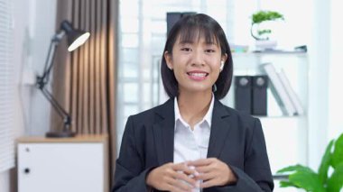 Masada çalışan Asyalı iş kadını dizüstü bilgisayar ve not defteri kullanarak müşteri ya da ofis binasıyla konuşuyor, yavaş çekim görüntüleri