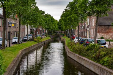 Hollanda 'da bir kanalda yol ve tuğla evler. Yaz. Hollanda.