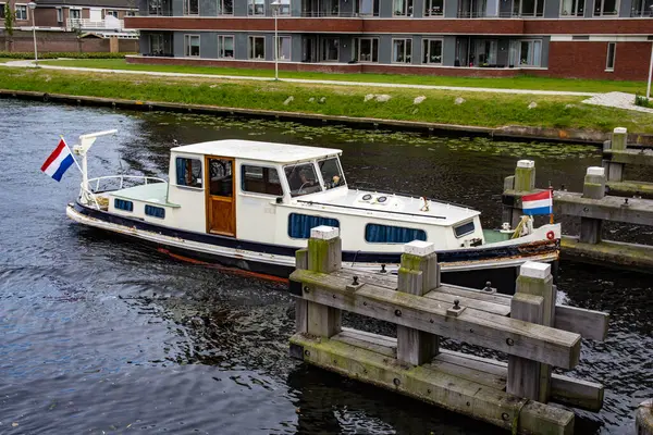 Bulutlu bir yaz gününde Hollanda 'da bir kanalda eğlence teknesi. Su..