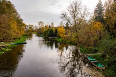Açık bir sonbahar gününde suyun üzerinde sarkan nehir ve ağaçlar.