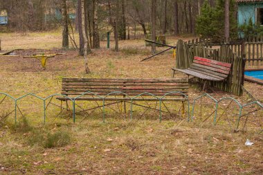 Kasvetli bir sonbahar gününde terk edilmiş bir tatil köyünde harap olmuş ve unutulmuş bir bank..