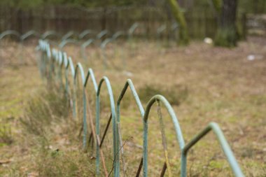 İhmal edilmiş ve terk edilmiş bir tatil köyünde eski bir bank ve metal bir çit..