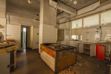 Kullanıcılardan kalan çöp, mobilya ve bardaklarla dolu terk edilmiş bir sanayi mutfağının içi.. 