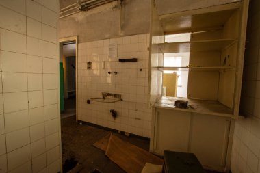 Kullanıcılardan kalan çöp, mobilya ve bardaklarla dolu terk edilmiş bir sanayi mutfağının içi.. 