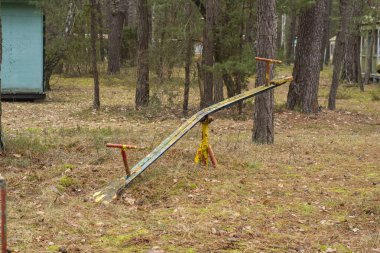 Ormandaki terk edilmiş ve unutulmuş bir tatil köyünde eski, harap bir çocuk salıncağı. Urbex.