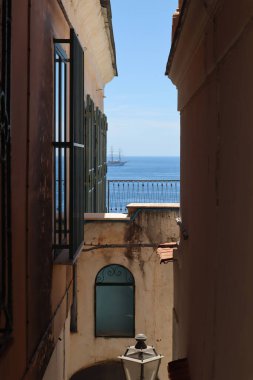 Güneşli bir yaz gününde denize bakan taş evleri olan resim gibi dar bir cadde, Atrani, İtalya