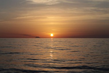 Gün batımında resim gibi bulutlar denizin üzerinde, ufukta Stromboli volkanı, İtalya, Calabria