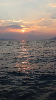 Gün batımında deniz manzaralı bulutlar ve güneş, ufukta dağların silueti, Brela, Hırvatistan