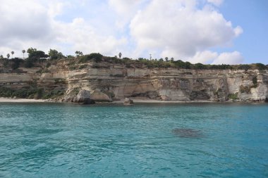 Uçurumları ve turkuaz suları olan sahili.