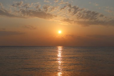 Yaz akşamında gün batımında bulutlu bir gökyüzü ve deniz.. 