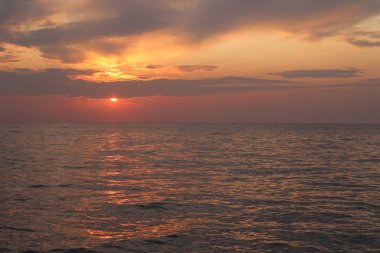  Resimli deniz ve bulutlu gökyüzü yaz akşamında gün batımında. 