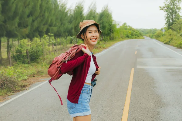 아시아 평상복 반바지 차림으로 여행을 모자를 아름다운 도로에서 포즈를 취한다 — 스톡 사진