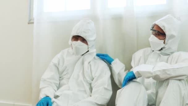 男医生和女医生流行病控制专家医生帮助感染Covid 19的病人摘下口罩和护目镜 坐在医院内的隔离病房里 — 图库视频影像