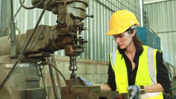 女性技術者労働者金属旋盤加工制御ドリルプレス電動ドリル工場ヘルメットゴーグル安全装置を身に着けている安全かつ効率的な作業親指アップと笑顔 — ストック動画