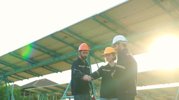 太陽光パネル発電所で働く電気技術者の男性と女性のチームが手を携えて 成功したメンテナンスで優れた地位を示す5つの高い — ストック動画