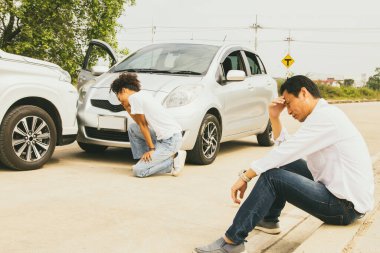 Asyalı adam ve Afro-Amerikalı kadın sürücü ciddi bir trafik kazasında tampon önünde, sigorta şirketinin hasarı temizleyip değerlendirmesini beklerken ciddi bir trafik kazası geçirdi..