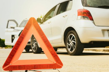Kırmızı yansıtıcı üçgen uyarı sembolünün kapatılması tehlike işareti: Yasa dışı kişisel arabaların kullanılması ve hasarla çarpışması: Araba sigortası tazminatı.