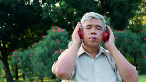 Asian Elderly Man Listening Music Entertaining Earphones Garden Leisure Activities — Vídeos de Stock