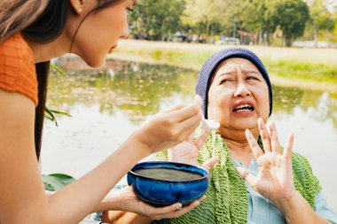Kanser hastası olan, vücudu ve sağlığı yerine gelsin diye çorba içen ama yemekten sıkılan bir anne, sağlıklı beslenmek istemeyen ve yiyemeyen yaşlı bir anneye bakıyor.