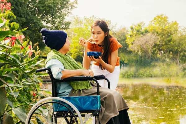 Asian family, grateful daughter takes care of mother who is sick and disabled with paralysis, feeds her food to restore her body and keep her healthy : Elderly insurance health care concept